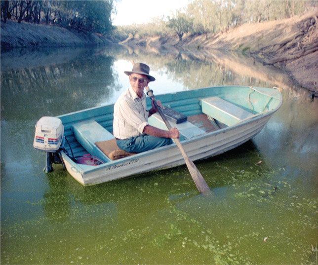 Source 4.22 A farmer paddling through an outbreak of blue-green algae on the Darling River, New South Wales