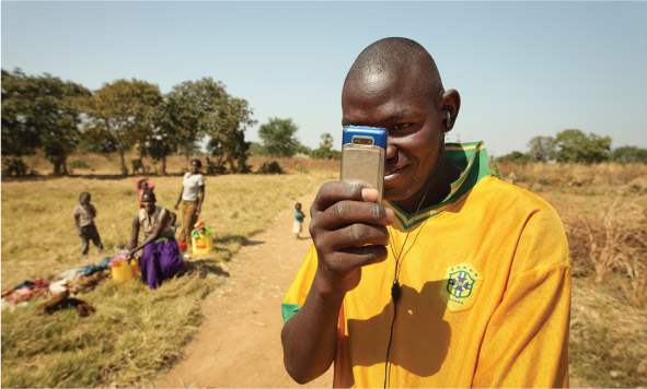 Source 8.11 Using a mobile phone to take photographs in rural Zambia