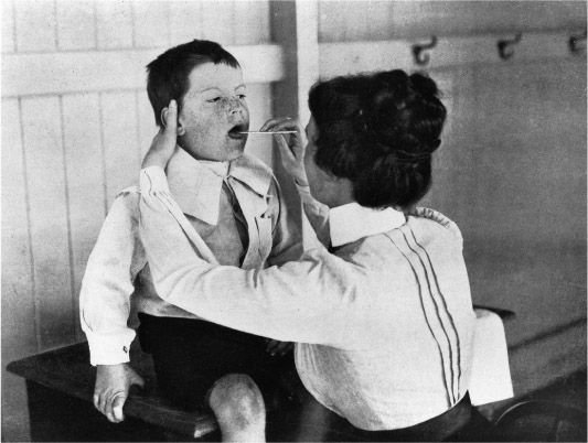 Source 14.27 A schoolboy receives a medical checkup from the school nurse, c. 1911. Defective vision, partial deafness and diseased teeth were common among schoolchildren at the time.